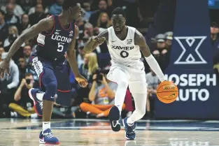  ?? JEFF DEAN/THE ASSOCIATED PRESS ?? Xavier guard Souley Boum tries to get past Connecticu­t’s Hassan Diarra during Saturday’s Musketeer win in Cincinnati. No. 24 Xavier beat the unbeaten Huskies 83-73.