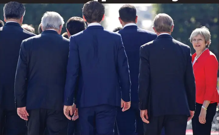  ??  ?? Any room for me? The Prime Minister tries to join the ranks of blue-suited EU leaders for a photo at the Salzburg summit yesterday