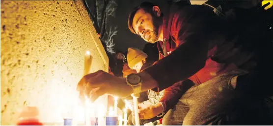  ?? LYLE ASPINALL ?? Romee Awan sets candles in place during a vigil outside City Hall on Monday. The event was held to support the Muslim community in the wake of a Quebec City shooting.