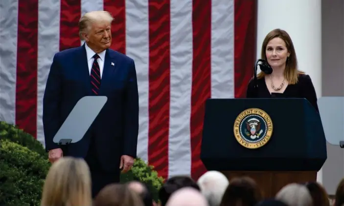 ?? Photograph: ChinaNews Service/Getty Images ?? Donald Trump listens as Amy Coney Barrett speaks at the White House in Washington DC, on 26 September.