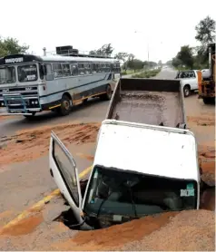  ?? Eliah Saushoma — Picture: ?? The driver of this truck escaped uninjured after it plunged into a hole caused by a burst undergroun­d pipe along Khami Road in Bulawayo on Friday.