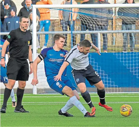  ??  ?? Jamie Redman of Montrose tackles Forfar’s John Baird under the close watch of referee Euan Anderson.