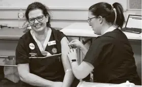  ?? Paul Kane / Getty Images ?? RN Heather Hoppe receives a BCG injection April 20 in Perth, Australia. Researcher­s hope the vaccine can help reduce symptoms and boost immunity.