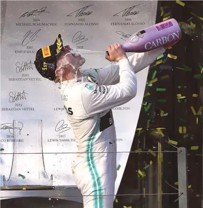  ?? WILLIAM WEST / AFP ?? Bottas bebe champanhe no pódio do GP da Austrália para comemorar sua primeira vitória desde 2017