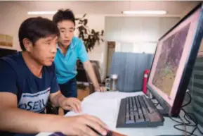  ?? by Duan Wei by Fang Shuo ?? At the Planning and Design Institute of the Saihanba forest farm, deputy chief Ji Fuli and engineer Yan Lijun discuss satellite images processed by the ARCGIS geographic informatio­n system. Guo Zhifeng, chief of the Pest Control Station of the Saihanba...