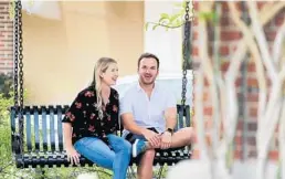  ?? RICH POPE/ORLANDO SENTINEL ?? Alyson Tata and her fiance, Beau Webster, sit in downtown Winter Garden on Tuesday. The couple had to postpone their March 21 wedding at the Omni Orlando Resort.