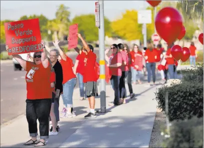  ?? Matt York ?? The Associated Press Teachers and students wave to motorists outside Paseo Verde Elementary Wednesday in Peoria, Ariz. Arizona teachers are weighing whether to walk out of their classrooms to demand more school funding after weeks of growing protests.