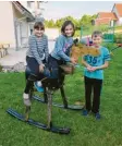  ??  ?? Lena-Marie, 10, Sonja, 9, und Michael, 13, haben von ihrem Papa ein besonderes Schaukelpf­erd bekommen. Der Rücken ist ein altes Ölfass und die Wippen unten sind alte Autoteile.