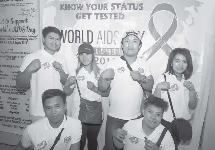  ?? Photo by Jean Nicole Cortes ?? KNOW YOUR STATUS. HIV-AIDS advocates show off their shirt with the symbolic ribbon to advocate awareness of the disease. More than 9.4 million people do not know that they are living with AIDS.