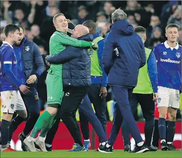  ?? — THE ASSOCIATED PRESS ?? Fourth-tier Oldham Athletic players and coaching staff celebrate after upsetting EPL side Fulham in the third round of English FA Cup yesterday.