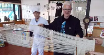  ??  ?? John is taught how to separate noodles on a loom-like machine in Shimbara city