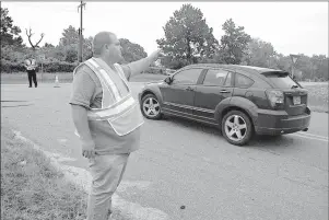  ?? Staff photo by Jim Williamson ?? Jim Bob Lamb motions to a motorist Friday morning after U.S. Highway 71’s southbound lanes were closed because of the rising Red River at Index, Ark., and near Ogden, Ark. While the Red River continues to flood, motorists will have to travel across the...