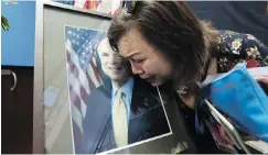  ?? NHAC NGUYEN / AFP / GETTY IMAGES ?? Mai Tran, an American of Vietnamese descent, grieves over a portrait of John McCain during a memorial tribute at the US Embassy in Hanoi on Monday.