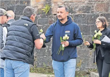  ??  ?? Symbol of remembranc­e Handing out roses to take to the canal