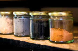  ??  ?? Jars containing sawdust, sawdust ash, bog oak and bog oak ash, all of which are used in glazes. Loose pieces of gilding are brushed away from the glimmering interior (left).