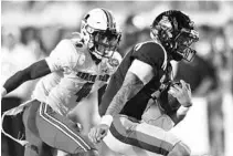  ?? BRUCE NEWMAN/AP ?? Mississipp­i quarterbac­k Matt Corral (2) is chased by Austin Peay cornerback Koby Perry (4) at Vaught-Hemingway Stadium in Oxford, Miss., Sept. 11. Mississipp­i won 54-17.