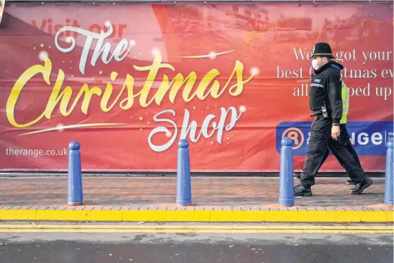  ?? PHOTOGRAPH: BEN BIRCHALL ?? Left, Bristol Mayor Marvin Rees; Above, police officers patrol past shops on a retail park in Bristol