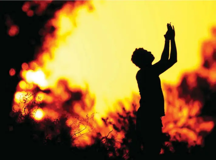  ??  ?? A hiker is silhouette­d against the evening sky while watching the sunset from Papango park Saturday, on Friday in Phoenix. Photo: AP