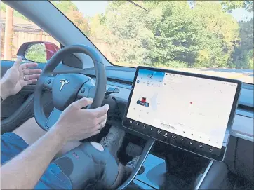  ?? COURTESY MEGAN CRUM ?? Rex Crum keeps his hands above the Tesla Model 3steering wheel as the car operates in Autopilot mode.