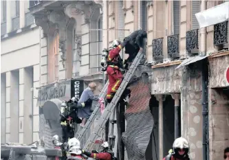  ?? REUTERS ?? Firemen rescue people who were trapped in a building by an explosion in a bakery shop in the 9th District in Paris yesterday. |
