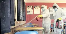  ?? | THEMBA HADEBE AP ?? A TEAM disinfects a classroom at Ivory Park Secondary School near Johannesbu­rg before the scheduled reopening of schools for Grade 7 and Grade 12 pupils today.