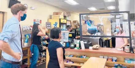  ?? FAWCETT/HARTFORD COURANT ELIZA ?? New Haven Mayor Justin Elicker and Director of Health Maritza Bond conduct a mask mandate compliance check Tuesday at a deli on Orange Street.