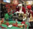  ?? ANDREW CASS — THE NEWS-HERALD ?? Santa signs a toy at the Lake Metroparks Farmpark toy workshop in Kirtland Dec. 23.