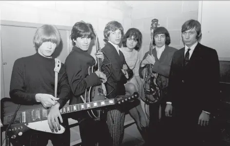  ??  ?? Rolling Stones guitarist Brian Jones, left, guitarist Keith Richards, vocalist Mick Jagger, bassist Bill Wyman and drummer Charlie Watts are seen with an unidentifi­ed woman as they prepared to rock the Vancouver Agrodome in 1965. A new album features...