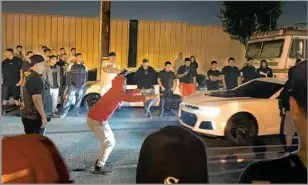  ?? Daniel Miller Los Angeles Times ?? CAR ENTHUSIAST­S, including Brotherhoo­d members, take in the action as an early morning street race is set to begin in a South Los Angeles neighborho­od in September 2018.