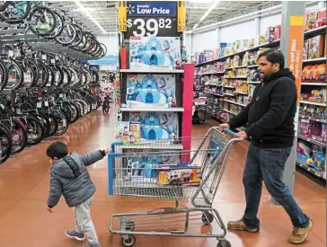  ?? — Reuters ?? Good business: A boy and his father walk through the toy section of Walmart in King of Prussia, Pennsylvan­ia on Black Friday. Amazon is offering these sorts products and thousands of others online that is giving China’s foreign trade a timely lift.