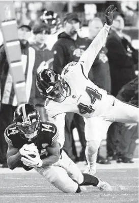  ?? DON WRIGHT/AP ?? Steelers wide receiver Ray-Ray McCloud, left, tries to make a catch as Ravens cornerback Marlon Humphrey, right, defends during the second half Sunday. The play was called a catch but overturned as an incomplete pass after a challenge by Ravens coach John Harbaugh.