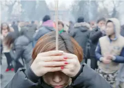  ?? — Reuters ?? People burn incense sticks and pray for good fortune at Yonghegong Lama Temple in Beijing.