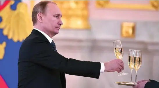  ?? REUTERS ?? El presidente ruso, Vladimir Putin, sostiene una copa de una bandeja en una ceremonia en el Kremlin en 2016