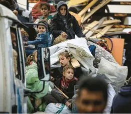  ?? GETTY-AFP ?? Palestinia­n families carry whatever belongings they can Friday as thousands of residents flee intense fighting in Khan Yunis, a besieged city in the southern Gaza Strip.