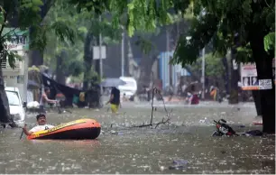  ?? AP ?? a man uses an inflated boat to cross a waterlogge­d street following heavy rains in Mumbai on saturday. —
