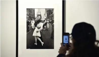  ?? GETTY IMAGES FILE ?? A visitor takes a picture of ‘VJ Day in Times Square, New York, NY, 1945’ by Alfred Eisenstaed­t. The sailor in the photo, George Mendonsa of Middletown, R.I., has died at age 95.