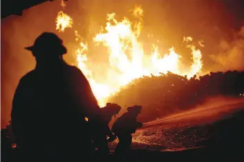  ?? — AFP ?? Firefighte­rs work to extinguish a fire inside the Mallorca Forest Company in San Ramon, 240 kilometres south of Santiago, on Thursday.