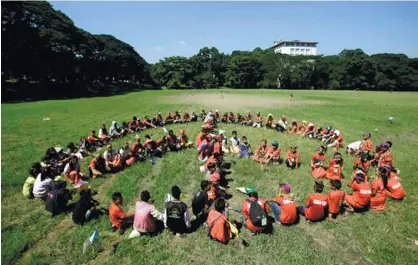  ?? (AP FOTO) ?? CALLING FOR JUSTICE. Children from the Philippine indigenous peoples known as ‘Lumads’ of Mindanao form a human peace symbol during a cultural activity at the University of the Philippine­s in Quezon City. The Lumads travelled to the country’s capital...