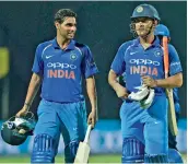  ??  ?? Bhuvneshwa­r Kumar and M.S. Dhoni.