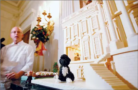  ?? (File Photo/AP/Charles Dharapak) ?? White House pastry chef Bill Yosses speaks Dec. 1, 2010, about the 2010 white chocolate-covered White House Gingerbrea­d House, featuring marzipan replicas of the Obama family dog, Bo, and the White House Kitchen Garden in the State Dining Room of the White House in Washington.