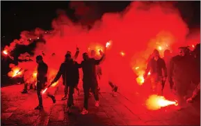  ??  ?? A parade of supporters in Piazza del Plebiscito, where a choreograp­hy with red smoke bombs was set up to remember Diego Maradona in Naples, Italy. The ex-naples player died this week