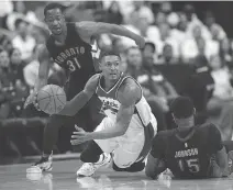  ?? ALEX BRANDON/THE ASSOCIATED PRESS ?? Bradley Beal passes the ball as he falls between Toronto forwards Terrence Ross and Amir Johnson.