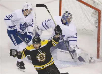  ?? The Associated Press ?? Boston Bruins forward Brad Marchand celebrates his goal in front of Toronto Maple Leafs goaltender Frederik Andersen and defenceman­RonHainsey­duringthef­irstperiod­ofGame1inN­HLplayoffa­ctiononThu­rsdayinBos­ton.TheBruinsw­on5-1.