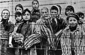  ?? ?? Hideous fate: Children behind the barbed wire at Auschwitz