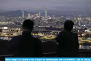  ?? — AFP ?? TAIPEI: People look towards a view of Taipei 101 and the skyline from Jiantansha­n in Taipei on January 9, 2024.