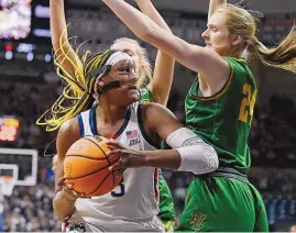  ?? JESSICA HILL/ASSOCIATED PRESS ?? UConn’s Aaliyah Edwards is guarded by Vermont’s Anna Olson, right, during Saturday’s NCAA Tournament game. The Huskies advanced with a 95-52 victory.