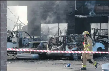  ?? Ted Rhodes, Calgary Herald ?? Firefighte­rs mop up Monday at the scene of an early morning fire that engulfed a commercial building in Westwinds Industrial Park, on 47th Street N.E. The blaze was reported at 1:45 a.m.