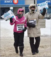  ?? Photos by Matthew Liebenberg/Prairie Post ?? Two STF members carry messages in support of their cause during the strike action in Swift Current, Jan. 22.