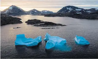  ?? FELIPE DANA THE ASSOCIATED PRESS FILE PHOTO ?? Large icebergs float away as the sun rises near Kulusuk, Greenland. Research suggests an alarming pace of change for Greenland’s ice sheet, the Earth’s second-largest body of ice.