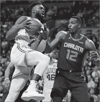  ?? CHARLES KRUPA/AP PHOTO ?? Hornets center Dwight Howard (12) knocks the ball loose on a drive to the basket by Celtics guard Jaylen Brown (7) during the first quarter of Wednesday’s game at Boston.